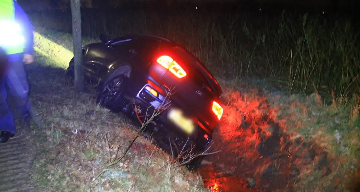 Spekglad wegdek, automobilist belandt in greppel