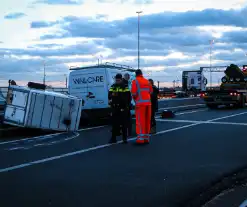 Bestelbus met aanhanger belandt op zijkant