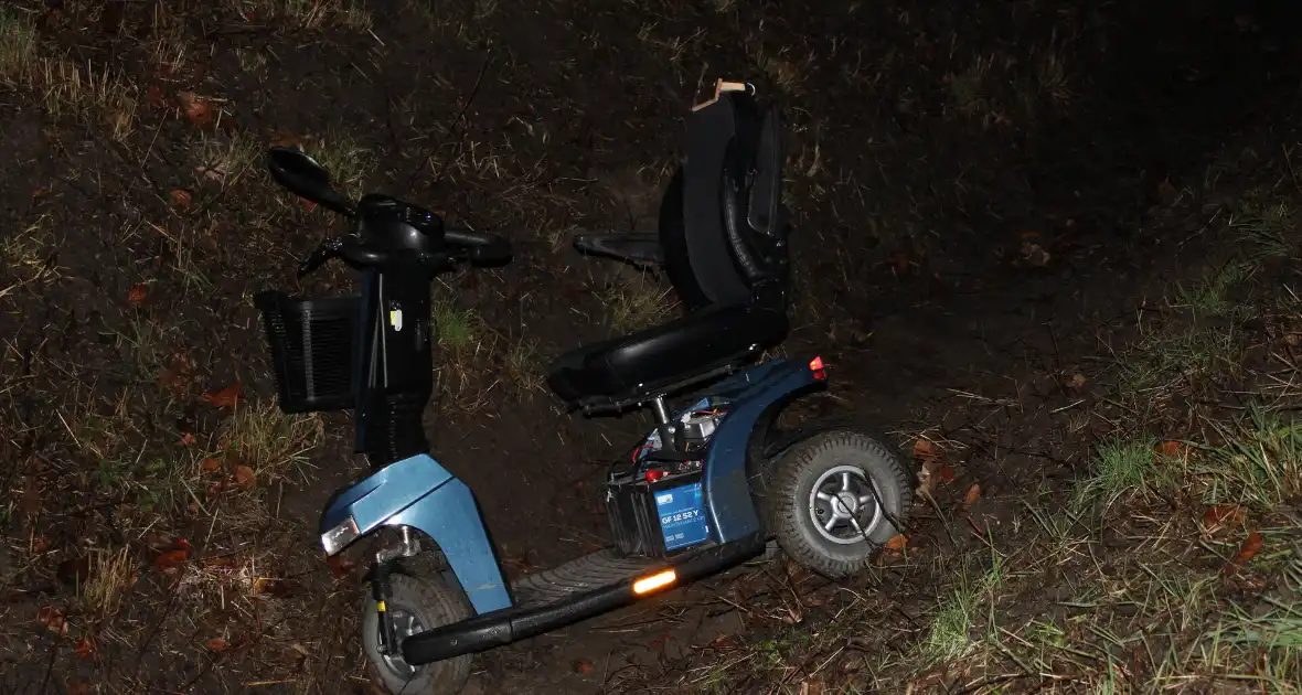 Persoon met scootmobiel in de sloot