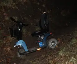 Persoon met scootmobiel in de sloot