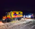 Politiejeep muurvast in los zand op strand