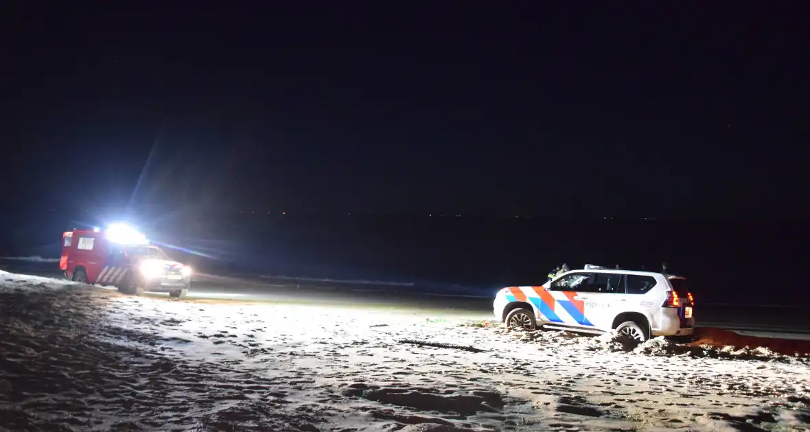 Politiejeep muurvast in los zand op strand - Foto 6