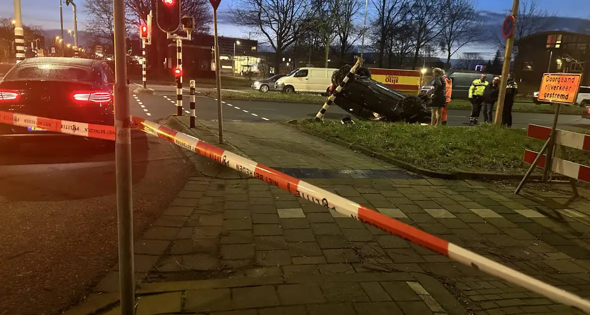 Auto knalt op verkeerslichten en slaat over de kop