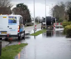 Straat onder water gelopen door kapotte waterleiding