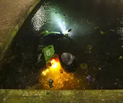 Personen dumpen scooter in vijver met karpers