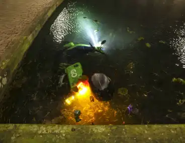 Personen dumpen scooter in vijver met karpers