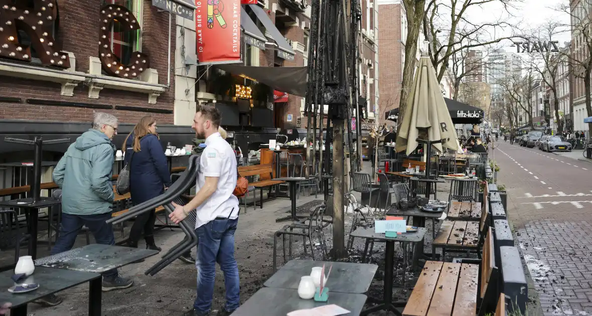 Parasol vat vlam op terras van café - Foto 15