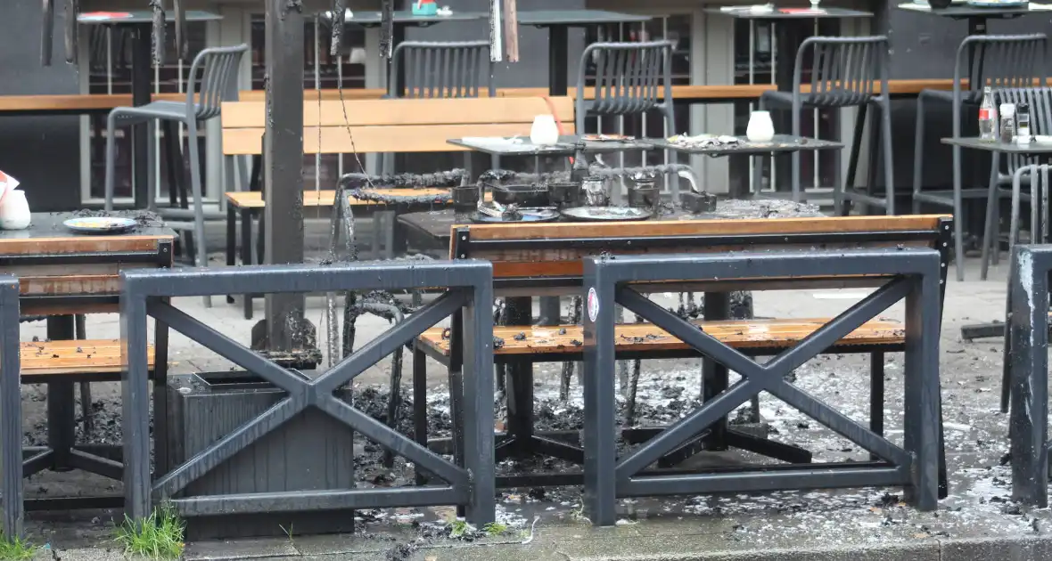 Parasol vat vlam op terras van café - Foto 7