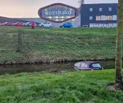 Auto rijdt van de dijk en belandt in het water