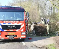 Auto raakt van de weg en belandt op zijkant in voortuin