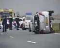 Auto op zijn kant na ongeval met vrachtwagen