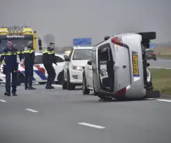 Auto op zijn kant na ongeval met vrachtwagen