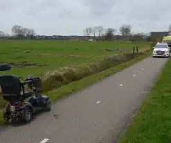 Persoon in scootmobiel raakt te water