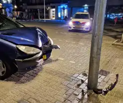 Personenwagen botst tegen lantaarnpaal