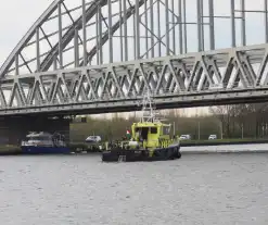 Persoon op bogen van brug, vele hulpdiensten aanwezig