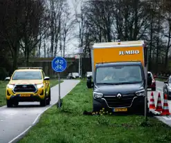 Jumbo bezorger raakt met bakwagen van weg en komt vast te zitten