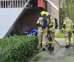 Motor in brand naast flatgebouw