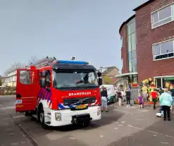 Kind bekneld tussen hek en betonnen container