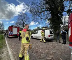 Brandweer blust brand achter woning