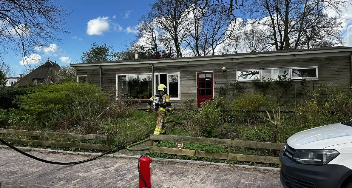 Brandweer blust brand achter woning - Foto 1