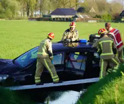 Automobilist raakt van de weg en blijft boven sloot hangen