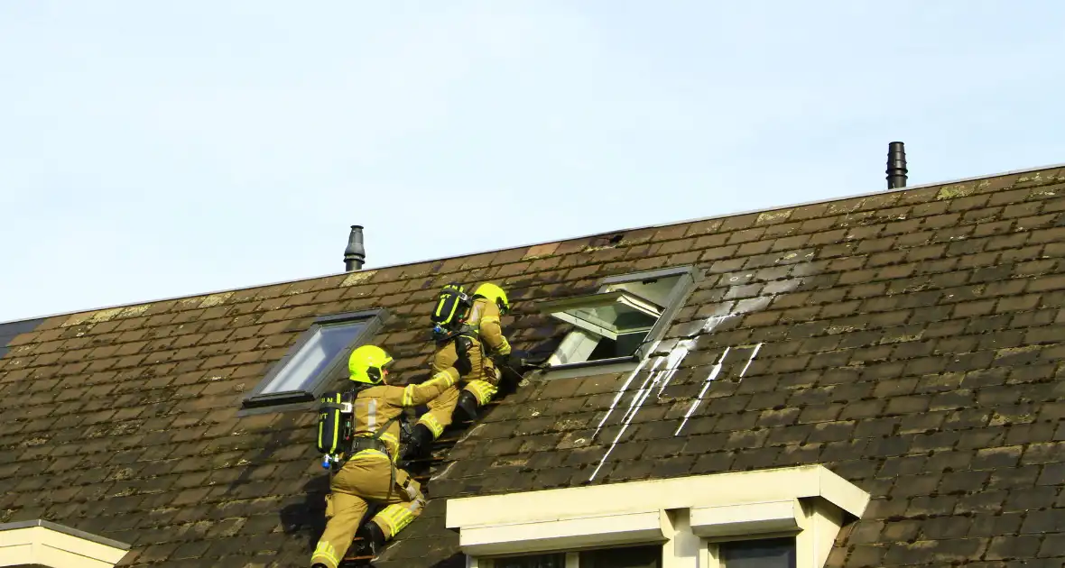 Brandweer breekt dak open om brand te bestrijden