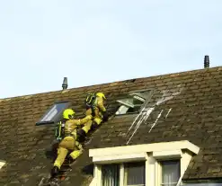 Brandweer breekt dak open om brand te bestrijden