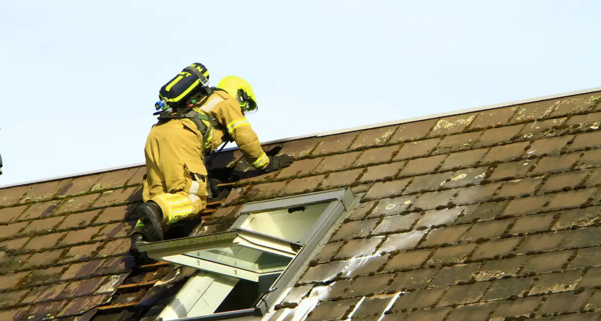 Brandweer breekt dak open om brand te bestrijden - Foto 1