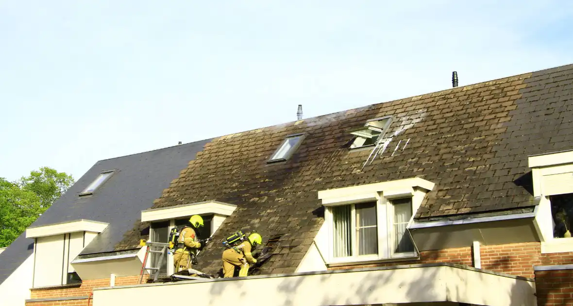 Brandweer breekt dak open om brand te bestrijden - Foto 12