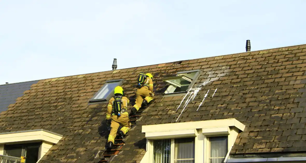 Brandweer breekt dak open om brand te bestrijden - Foto 5