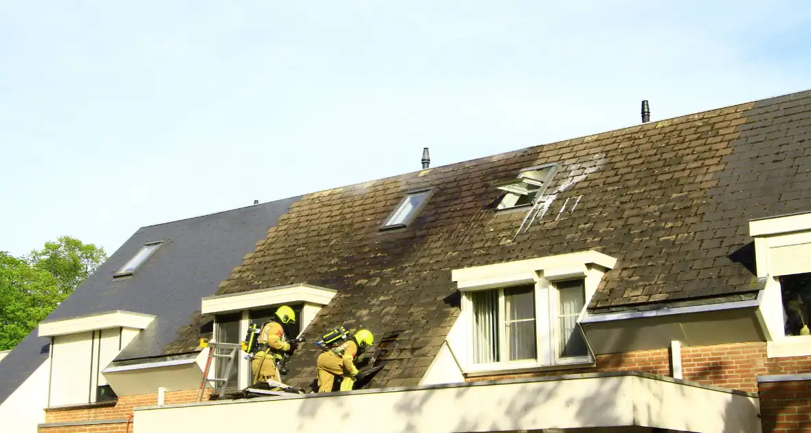 Brandweer breekt dak open om brand te bestrijden - Foto 8