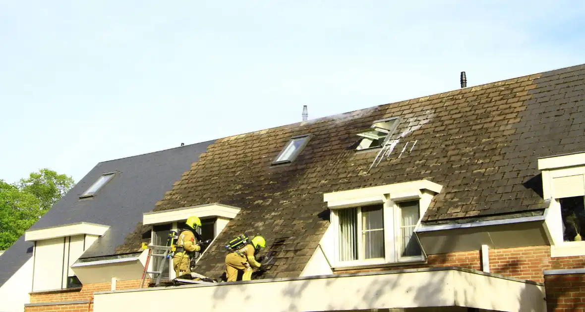 Brandweer breekt dak open om brand te bestrijden - Foto 9