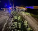 Vrachtwagen ramt boom en belandt op zijkant in sloot