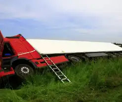 Vrachtwagen op zijn kant in sloot