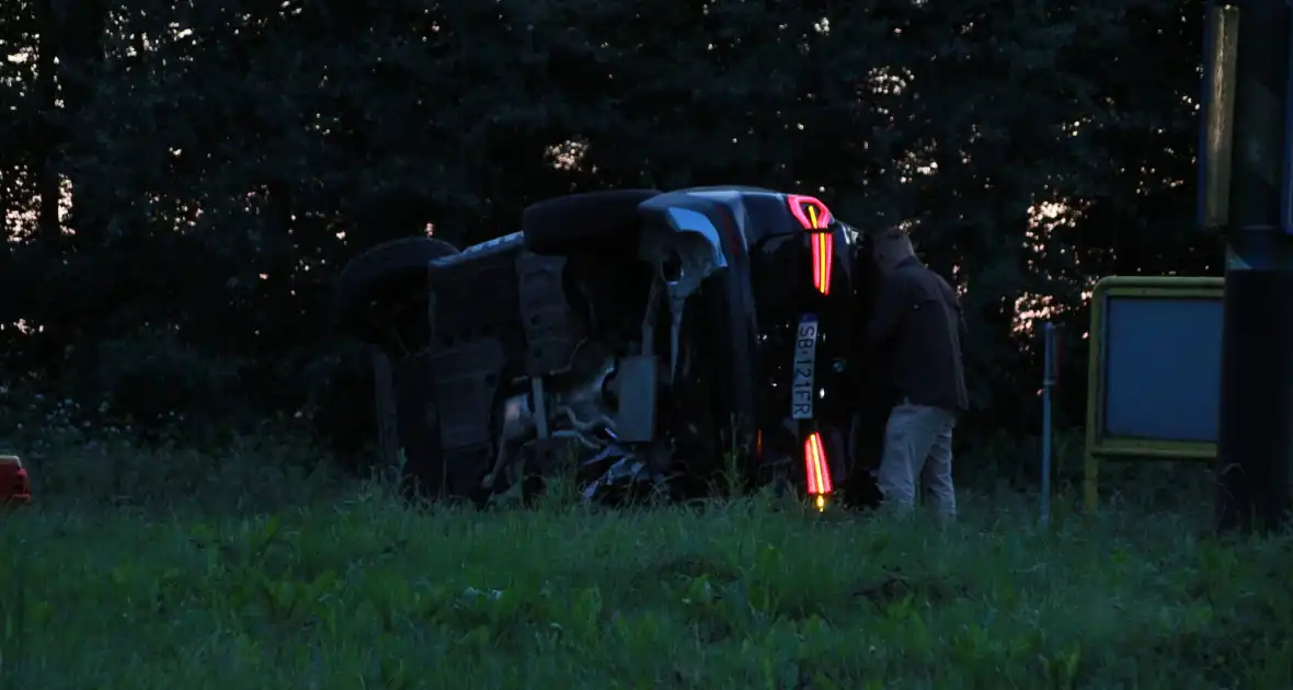 Auto op zijn kant na opmerkelijk ongeval op rotonde - Foto 5