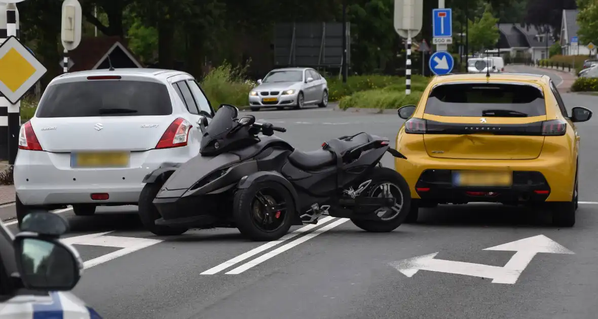 Driewiel motor rijder botst achterop twee auto's