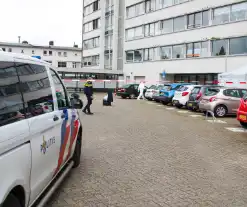 Forensisch onderzoek op parkeerplaats naast flatgebouw