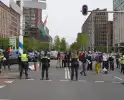 Demonstranten trekken persoon van scooter en slaan op auto's
