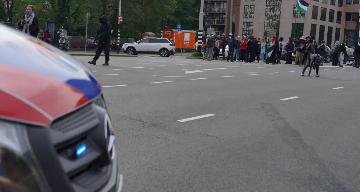 Demonstranten trekken persoon van scooter en slaan op auto's - Foto 3