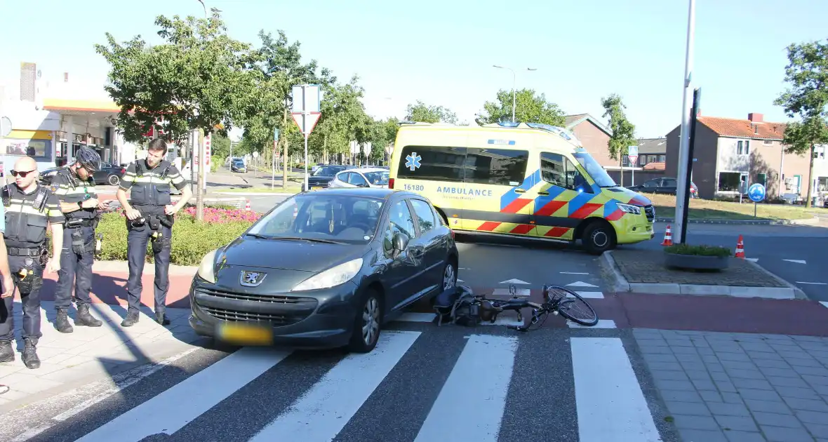 Fietser klapt op zijkant van auto tijdens het oversteken op rotonde