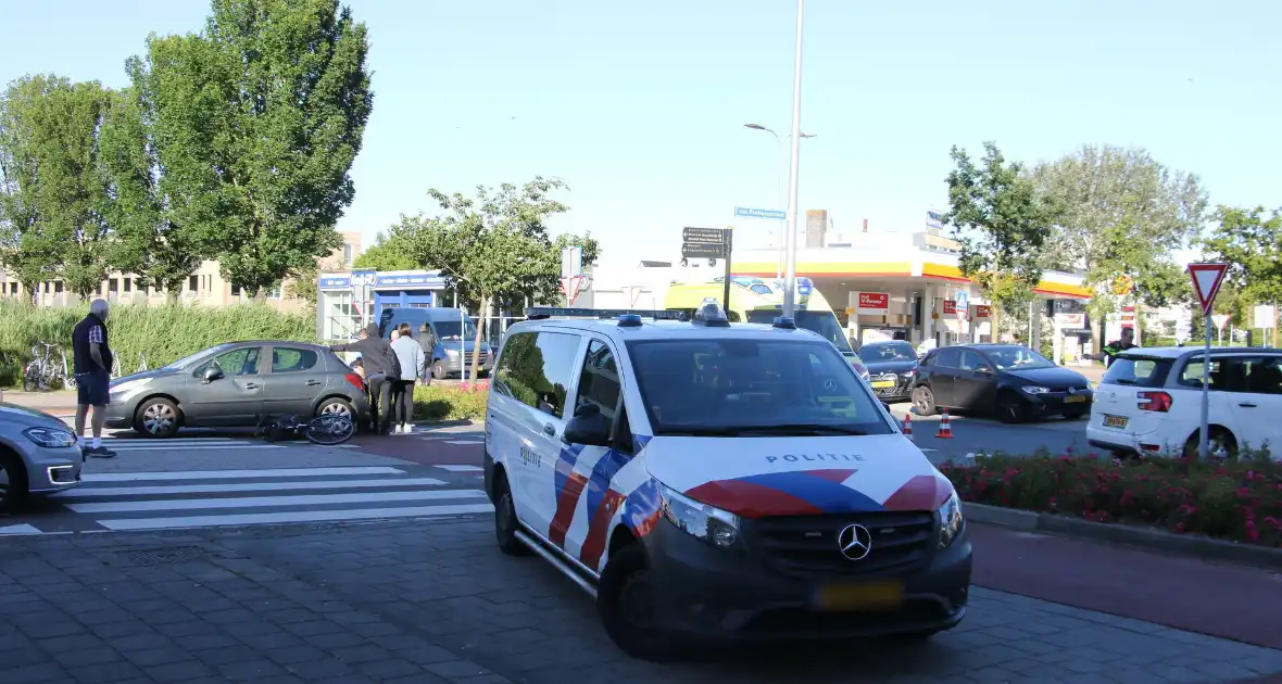 Fietser klapt op zijkant van auto tijdens het oversteken op rotonde - Foto 2