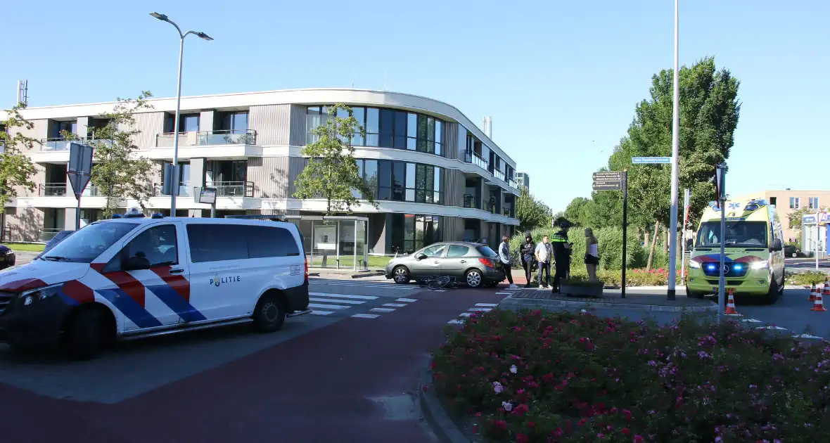 Fietser klapt op zijkant van auto tijdens het oversteken op rotonde - Foto 3