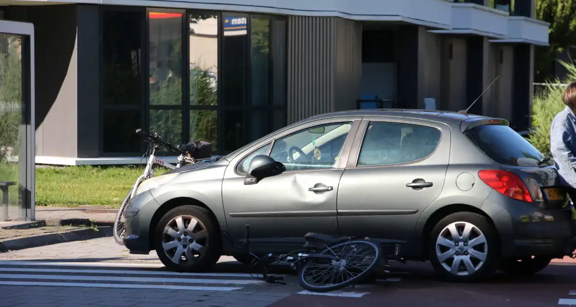 Fietser klapt op zijkant van auto tijdens het oversteken op rotonde - Foto 4