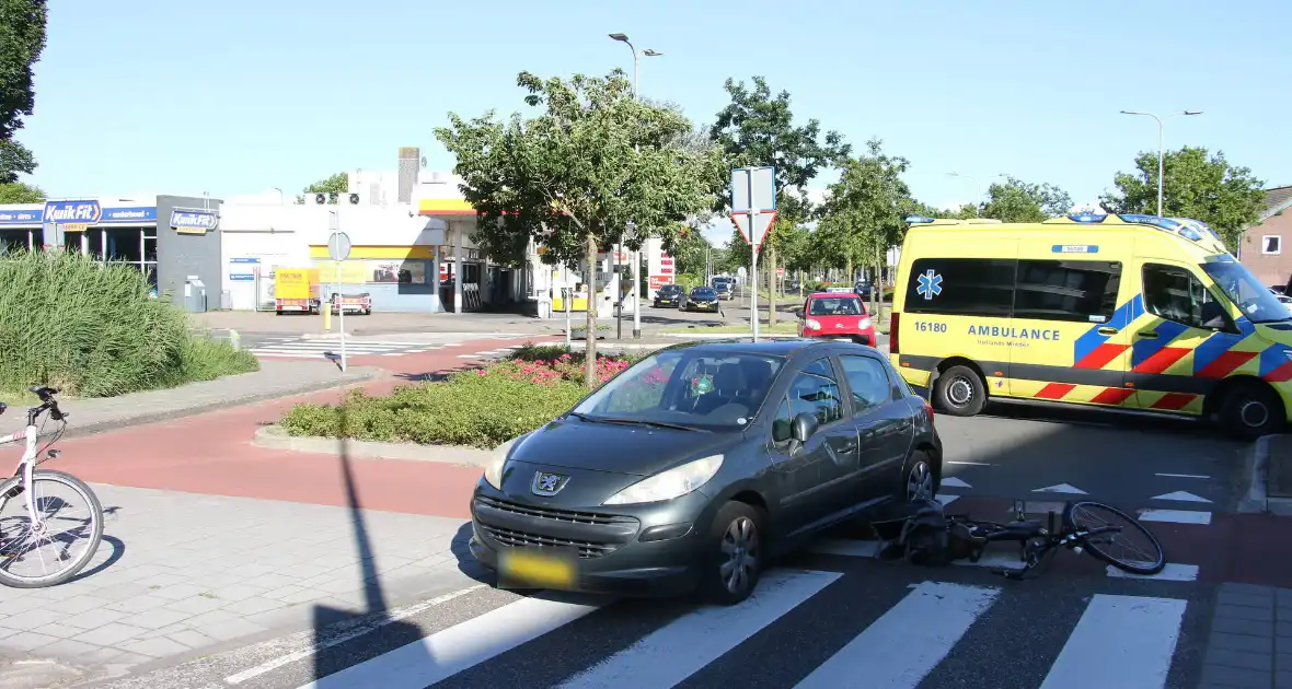 Fietser klapt op zijkant van auto tijdens het oversteken op rotonde - Foto 5