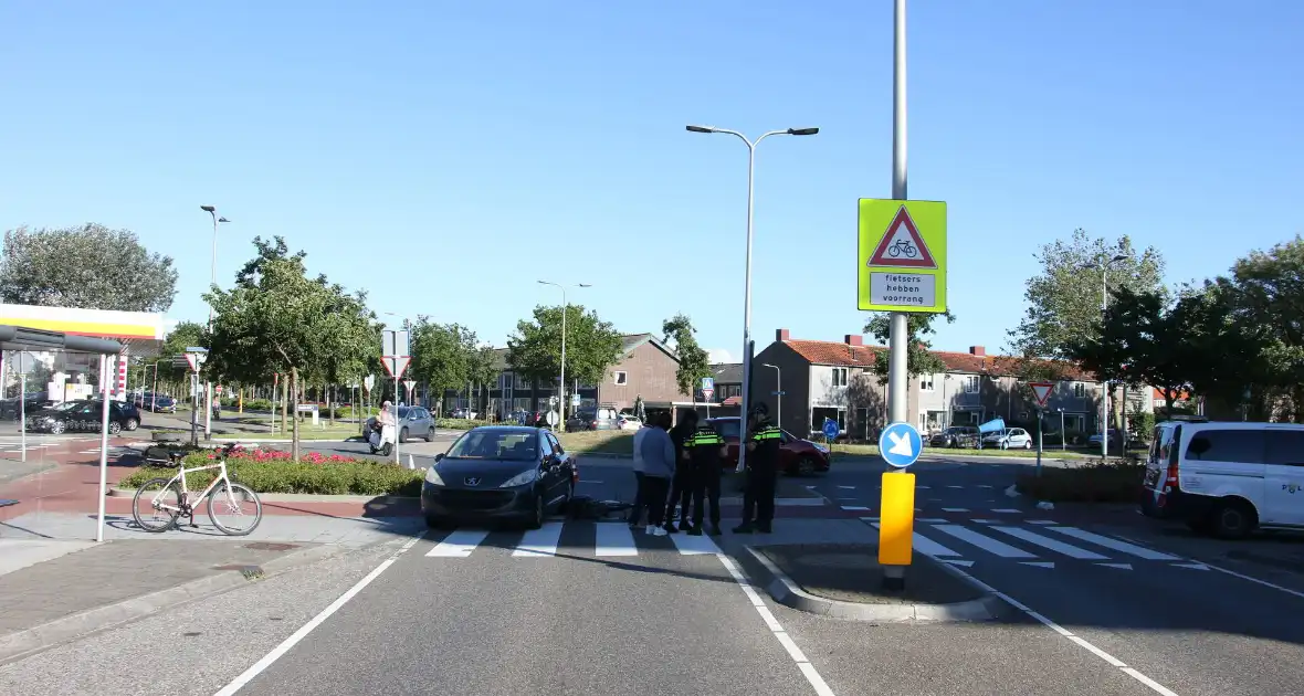 Fietser klapt op zijkant van auto tijdens het oversteken op rotonde - Foto 8