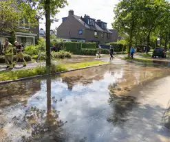 Straat blank door een gesprongen waterleiding