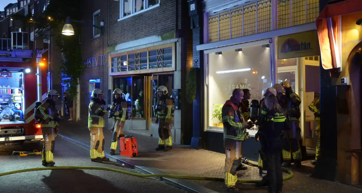 Deur opengebroken vanwege brand in winkelpand - Foto 6