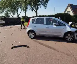 Bestelbus belandt op zijkant na frontale botsing op kruising, automobilist gewond