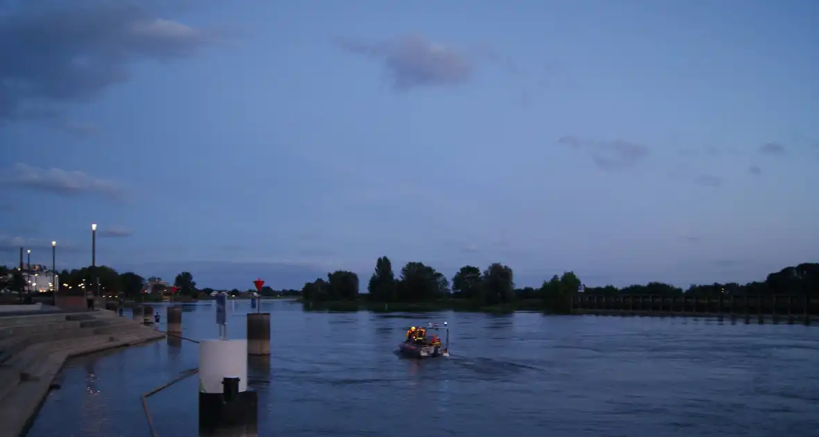 Baasjes springen hond achterna die in water ligt - Foto 3