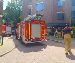 Voorbijganger onder brand in flat